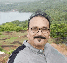 a man with glasses and a mustache is taking a selfie