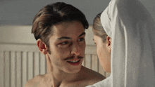 a shirtless man with a mustache is looking at a nun