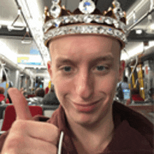 a man with a crown on his head is giving a thumbs up