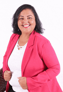 a woman wearing a pink jacket and a white top smiles for the camera