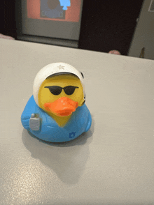 a rubber duck wearing sunglasses and a helmet is on a table