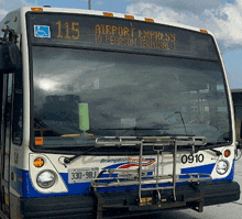 a blue and white bus with the number 115 on it