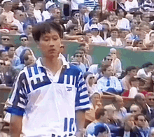 a man stands in front of a crowd wearing a blue and white shirt with the number 11 on it