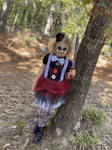 a little girl dressed as a clown holds a knife