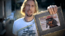 a man is holding up a picture of a dachshund wearing a hat