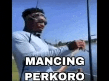 a man is fishing in a lake with a fishing rod and a caption that says mancing perkoro .