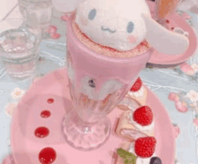 a pink sundae with a stuffed animal on top of it is on a pink plate .