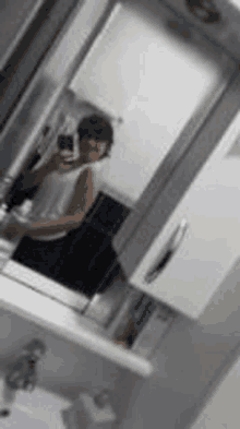 a person is taking a picture of themselves in a bathroom mirror .