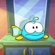 a blue and yellow cartoon fish is sitting on a cabinet