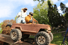 a toy jeep with a tonka tire sits on top of a wooden ramp