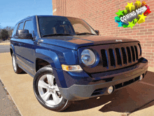 a blue jeep is parked in front of a brick building