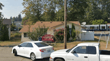 a white dodge ram truck is parked in front of a house with a train behind it