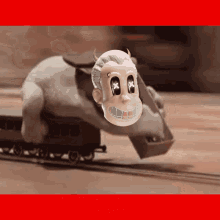 a cartoon character with horns and crossed eyes is riding on a train