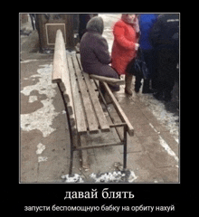 two elderly women are sitting on a wooden bench in the snow .