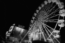 a black and white photo of a ferris wheel in front of a darcov building