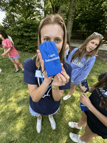 a woman holding a blue bag that says i am becoming