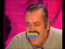 a man with a mustache is laughing with a rainbow in his mouth .