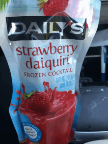 a bag of daily 's strawberry daiquiri frozen cocktail sits in a car