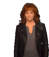 a woman with red hair is wearing a black jacket