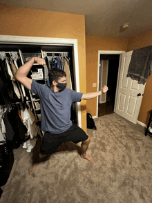 a man wearing a mask stands in a closet