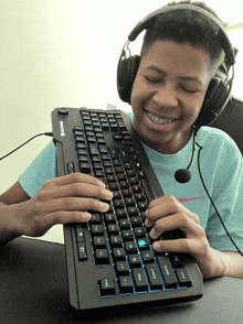 a boy wearing headphones is typing on a keyboard that says " thunder " on it