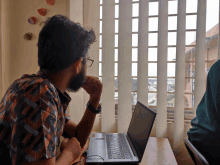 a man sitting at a desk with a laptop on it