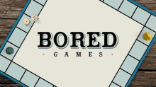 a board game with the words `` bored games '' written on it is sitting on a wooden table .