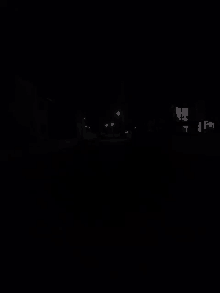 a dark street with a few lights on the side of it