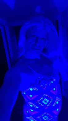 a woman in a glow in the dark swimsuit is taking a selfie