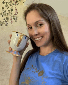 a woman is holding a mug with a face on it .