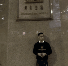 a man wearing a black balenciaga sweater is standing in front of a building