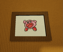 a picture of kirby in a wooden frame on a wooden wall