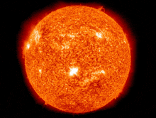 a close up of a bright red sun with a black background