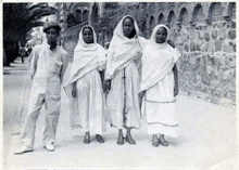 a group of people standing next to each other wearing white clothes