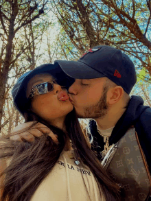 a man kisses a woman on the cheek while wearing a louis vuitton purse