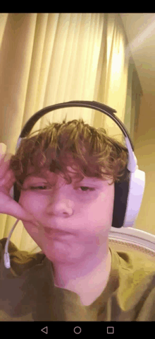 a young boy wearing headphones making a face