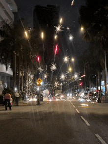 fireworks are being displayed on a street with a yellow sign that says ' a ' on it