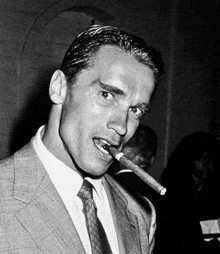 arnold schwarzenegger smoking a cigar in a black and white photo