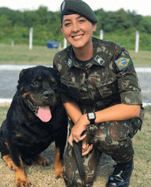 a woman in a military uniform kneeling next to a dog with the name xavier on her shirt