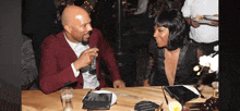 a man and a woman are sitting at a table talking