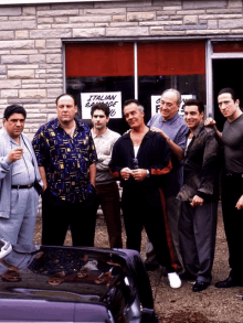 a group of men are standing in front of a building that says italian sausage