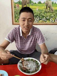 a man is sitting at a table eating a bowl of soup