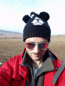 a man wearing a red jacket and a black hat with ears