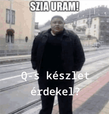 a man in a black jacket is standing in front of a building with the words szia uram