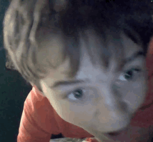 a close up of a child 's face with a green screen behind it