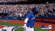 a baseball player for the blue jays is running on a field