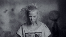 a black and white photo of a woman with white hair and a dirty shirt