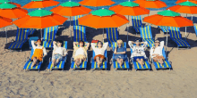 a group of people laying on a beach under umbrellas