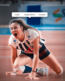 a woman in a movistar jersey is kneeling on the floor with her mouth open