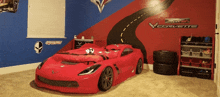 a bedroom with a red corvette bed